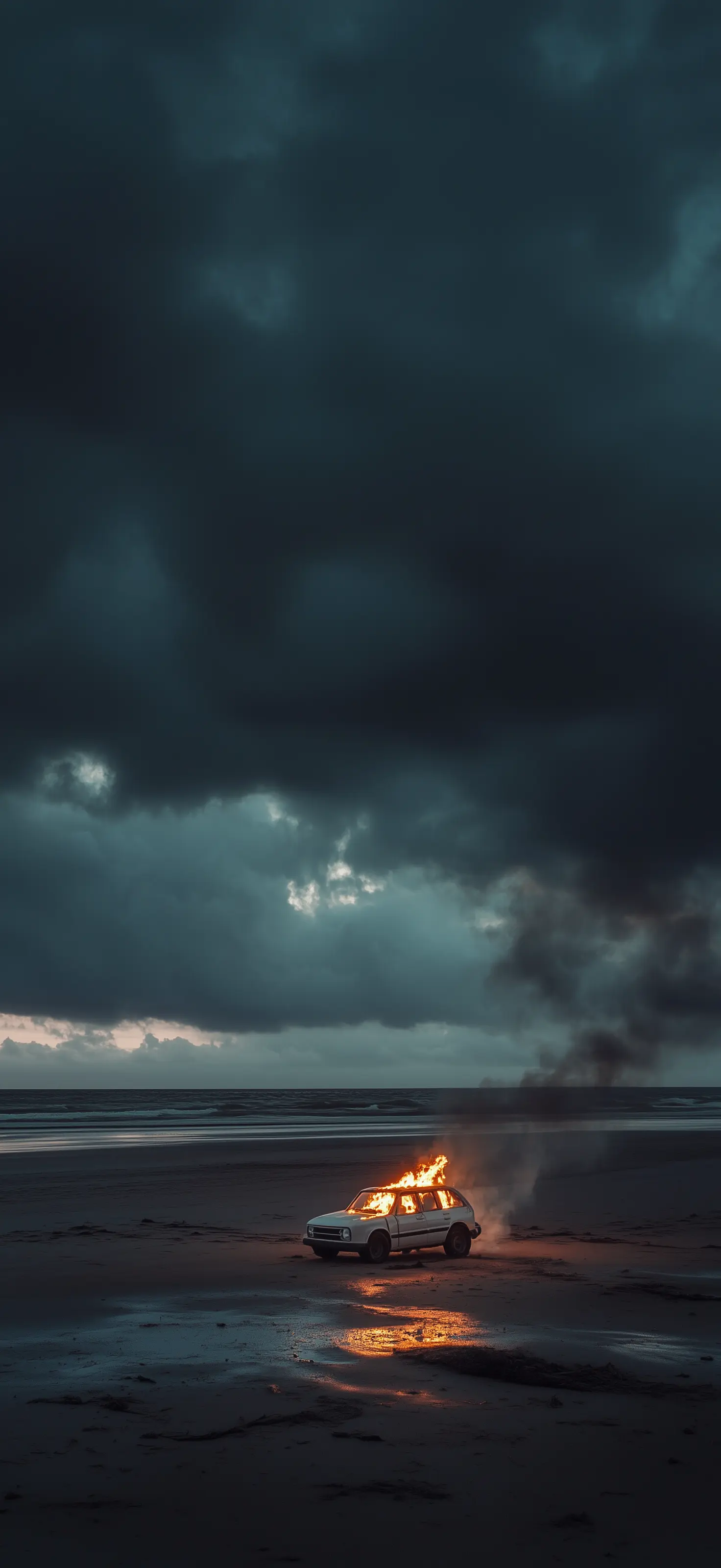 I drove my past as far as it would take me, then set it ablaze where the land surrenders to endless blue Car burning on empty beach under stormy sky with dark clouds and ocean horizon